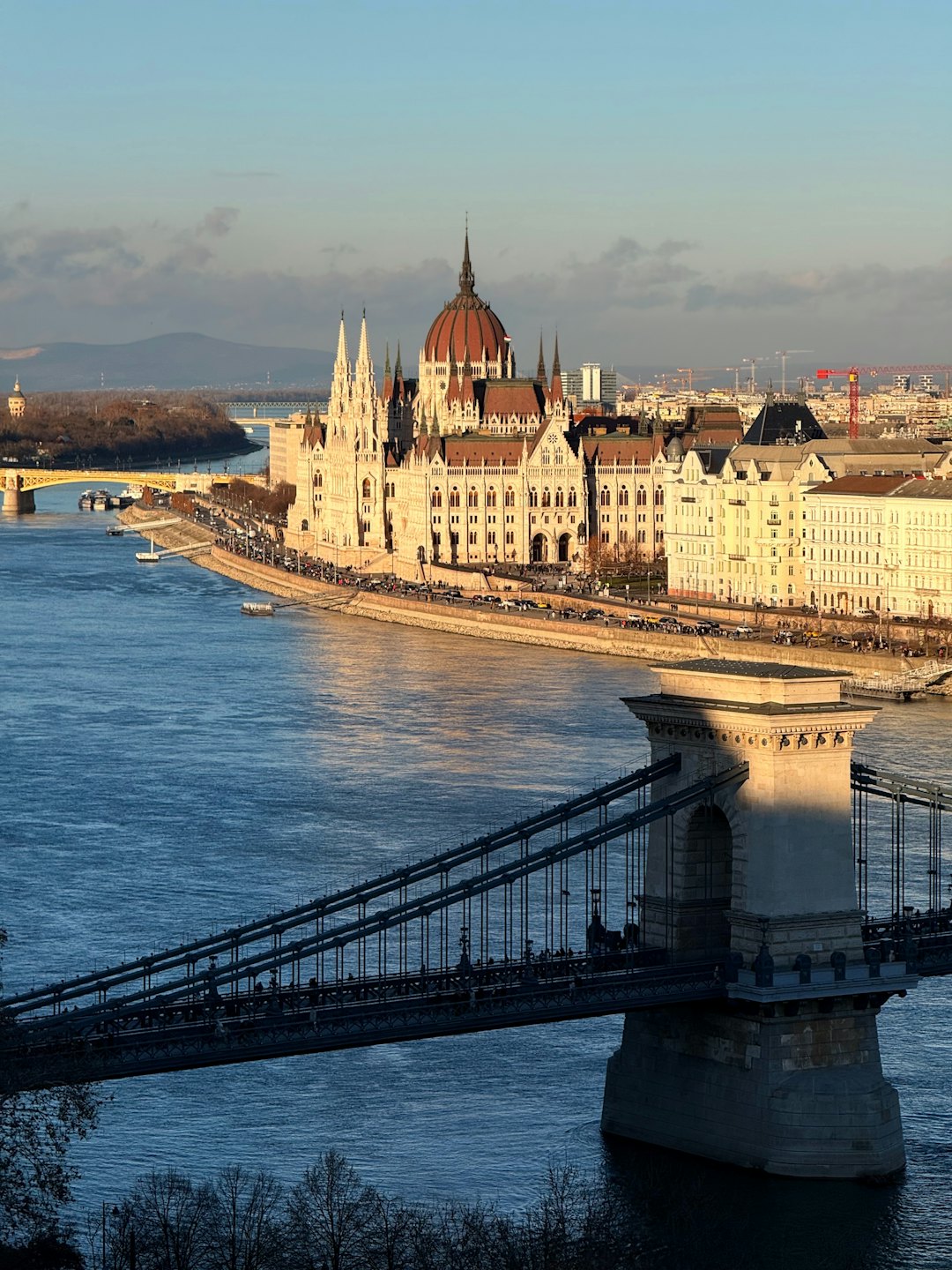 Ornate parliament building with a red dome beside a river.